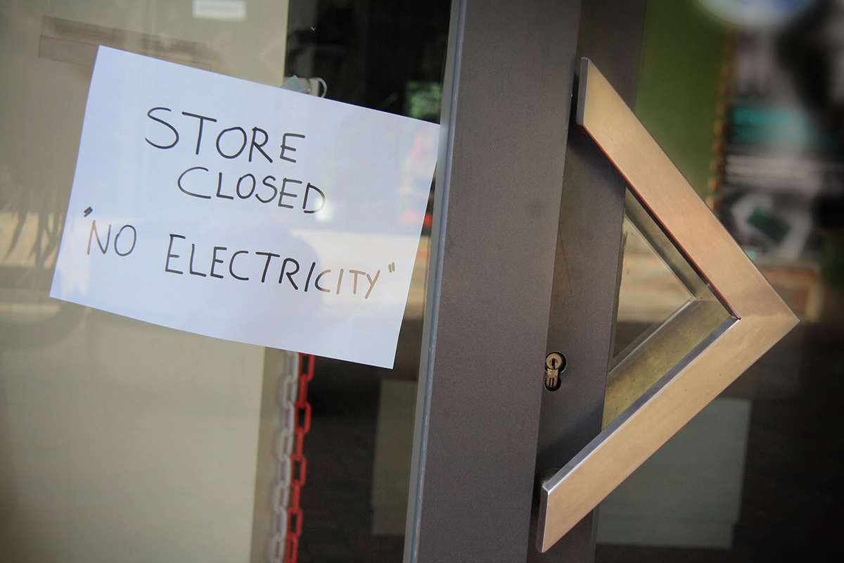Storefront door with sign reading store closed no electricity during power outage